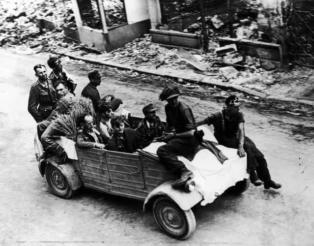 German troops drive into the French town of Trun under a white flag of surrender, 1944. (Photo by Keystone)