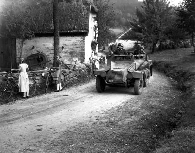Watched by young Czech women with bicycles a German armoured car drives through Waldhaeus in Czechoslovakia, an invasion which led up to WWII. 3rd October 1938. (Photo by Keystone)