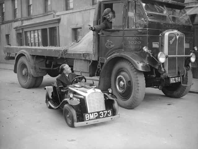 A lorry driver talking to the driver of a midget car in Cardiff, February 1935. (Photo by Fox Photos)