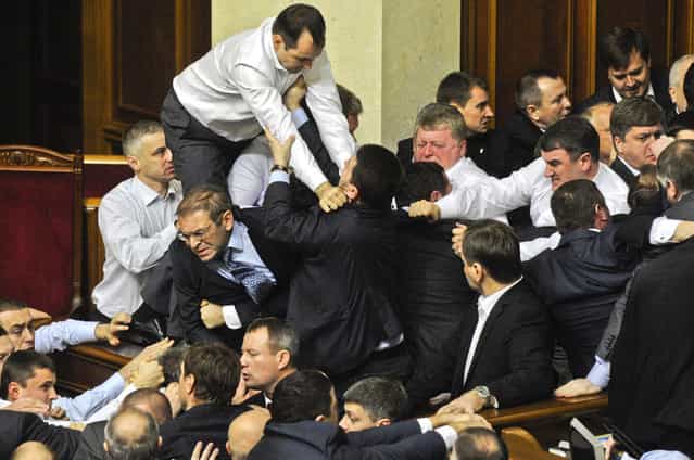 Lawmakers fight around the rostrum during the first session of Ukraine's newly elected parliament in Kiev, Ukraine, December 13, 2012. (Photo by Sergei Chuzavkov/Associated Press)