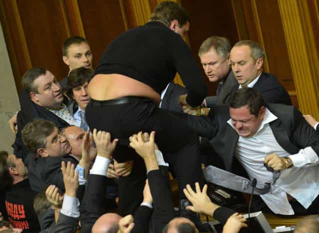 Deputies of the opposition fight with deputies of majority party during the opening of the newly elected Ukrainian parliament in Kiev on December 12, 2012. Activists from Ukraine's feminist group Femen staged a topless anti-corruption protest on Wednesday outside the ex-Soviet country's newly-elected parliament as a fight erupted between lawmakers inside. Ukraine's parliament has seen several physical confrontations in recent years amid bitter confrontation between opposition and pro-government camps. AFP PHOTO/SERGEI SUPINSKY
