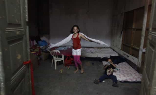 Siblings, who are children of members of Brazil's Movimento dos Sem-Teto (Roofless Movement), play in a vacant apartment in one of the 11 empty buildings that the movement took over recently, in the centre of Sao Paulo, November 6, 2012. According to City Hall, there are some 400,000 people in need of stable housing, including the 4,000 families of the Roofless Movement who are squatting in abandoned or vacant buildings that range from apartment blocks to hotels, in Sao Paulo, the largest city in South America. Picture taken November 6, 2012