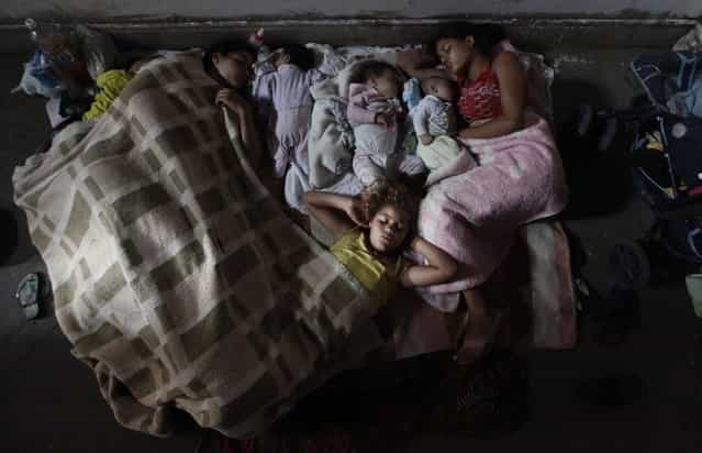 Members of Brazil's Movimento dos Sem-Teto (Roofless Movement) sleep on the floor of a vacant apartment in one of the 11 empty buildings that the movement took over in one night, in the centre of Sao Paulo, October 29, 2012. According to City Hall, there are some 400,000 people in need of stable housing, including the 4,000 families of the Roofless Movement who are squatting in abandoned or vacant buildings that range from apartment blocks to hotels, in Sao Paulo, the largest city in South America. (Photo by Nacho Doce/Reuters)