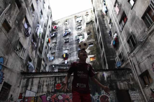 A member of Brazil's Movimento dos Sem-Teto (Roofless Movement) plays with a soccer ball in the courtyard of one of the 11 empty buildings that the movement took over recently, in the centre of Sao Paulo, November 18, 2012. According to City Hall, there are some 400,000 people in need of stable housing, including the 4,000 families of the Roofless Movement who are squatting in abandoned or vacant buildings that range from apartment blocks to hotels, in Sao Paulo, the largest city in South America. Picture taken November 18, 2012