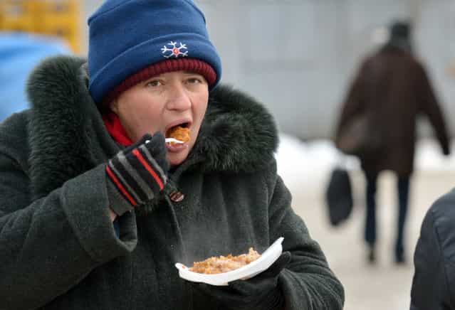 Homeless people queue to get free hot food organized by social services during a frosty winter's day in Kiev on December 18, 2012. Nineteen people died of exposure in Ukraine in the last 24 hours amid temperatures of minus 20 degrees Celsius (minus 4 degrees Fahrenheit), bringing the toll this month to 37, the health ministry said Tuesday. (Photo by Sergei Supinsky/AFP Photo)