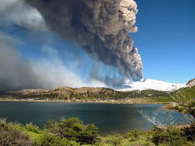 View of the Copahue volcano spewing ashes behind the lagoon of Caviahue, Neuquen province, Argentina, some 1500 km southwest of Buenos Aires on December 22, 2012. The authorities of Chile and Argentina issued yellow alerts due to the eruption of the Copahue volcano, placed in the border between both countries. (Photo by Antonio Huglich/AFP Photo)