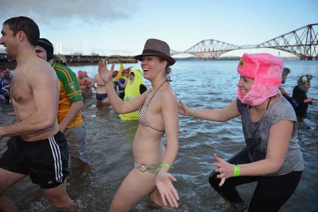 Over 1,000 New Year swimmers, many in costume, braved freezing conditions in the River Forth in front of the Forth Rail Bridge during the annual Loony Dook Swim on January 1, 2013 in South Queensferry, Scotland. Thousands of people gathered last night to see in the New Year at Hogmanay celebrations in towns and cities across Scotland. (Photo by Jeff J. Mitchell)
