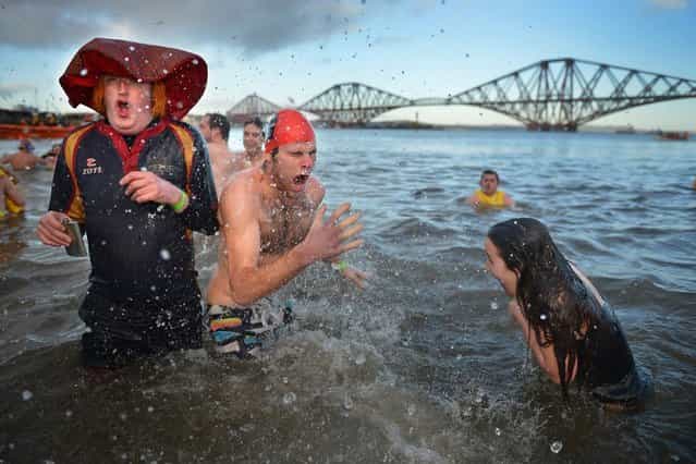 Over 1,000 New Year swimmers, many in costume, braved freezing conditions in the River Forth in front of the Forth Rail Bridge during the annual Loony Dook Swim on January 1, 2013 in South Queensferry, Scotland. Thousands of people gathered last night to see in the New Year at Hogmanay celebrations in towns and cities across Scotland. (Photo by Jeff J. Mitchell)