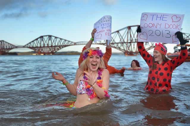 Sarah Johnston reacts to the water temperature as she joins around 1,000 New Year swimmers, many in costume, in front of the Forth Rail Bridge during the annual Loony Dook Swim in the River Forth on January 1, 2013 in South Queensferry, Scotland. Thousands of people gathered last night to see in the New Year at Hogmanay celebrations in towns and cities across Scotland. (Photo by Jeff J. Mitchell)