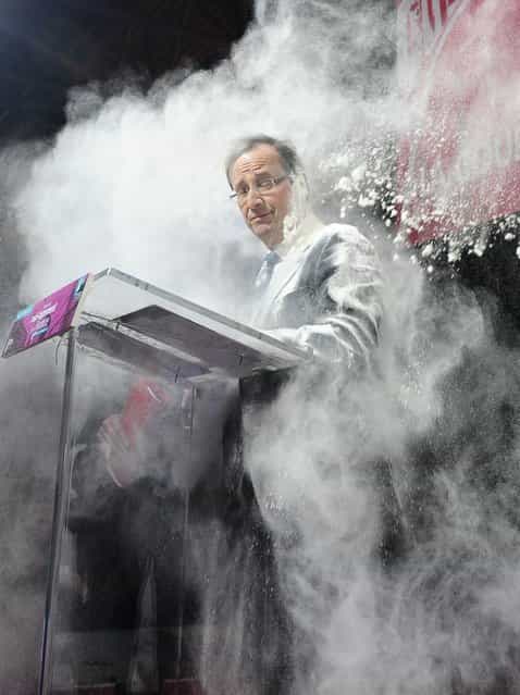 In this February 1, 2012 file photo, an unidentified woman throws flour on French Socialist Party candidate for the 2012 presidential elections, Francois Hollande, in Paris. The woman ran to the side of the podium where Hollande stood to sign a [social contract] in favor of housing for all. (Photo by AP Photo/SZG)