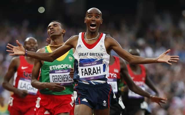 Britain’s Mohamed Farah celebrates as he crosses the finish line to win the men’s 5000-meter final during the athletics in the Olympic Stadium at the 2012 Summer Olympics, London, Saturday, August 11, 2012. (Photo by Anja Niedringhaus/AP Photo)