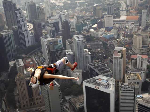 France's base jumper Florian Pays gestures while leaping from Malaysia's landmark KL Tower, the 421-meter (1,389-foot) broadcasting tower in downtown Kuala Lumpur, Malaysia, September 29, 2012. (Photo by Vincent Thian/AP Photo)