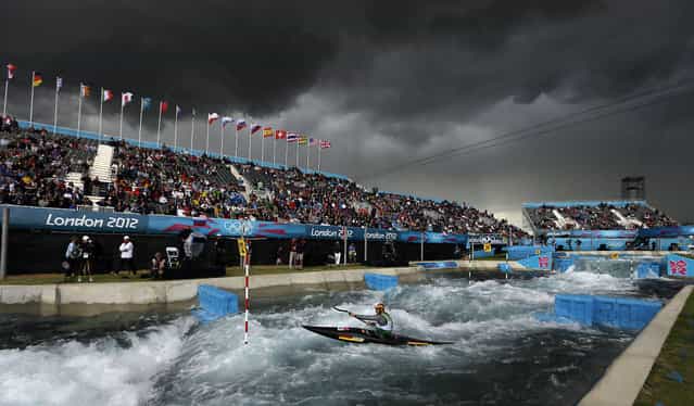 The sky turns black before a heavy rain shower as Germany's Hannes Aigner competes in the heats of the K-1 men's canoe slalom at Lee Valley Whitewater Center, at the 2012 Summer Olympics, July 29, 2012, in London. (Photo by Kirsty Wigglesworth/AP Photo)