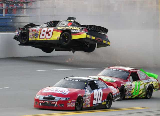 Zach Ralston (90) and Brett Hudson (11) drive past the flipping car of Mike Affarano (83) during the International Motorsports Hall of Fame 250 ARCA auto race at the Talladega Superspeedway in Talladega, Ala., May 4, 2012. (Photo by Dave Martin/AP Photo)