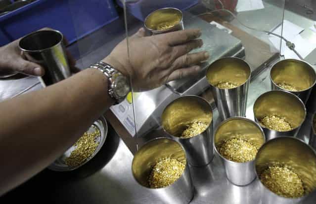 Technician prepares 1 Kg containers of gold grains for melting into 995.0 purity gold bars at the Emirates Gold refinery in Dubai, United Arab Emirates. Dubai now has about a 29 percent market share of global gold trade with nearly 1,200 tons – worth about $41 billion – changing hands annually in the city's gold markets, according to the gold industry website bullionstreet.com. At the Dubai Gold and Commodities Exchange, traders and speculators buy and sell the metal on the futures market. (Photo by Kamran Jebreili/AP Photo)