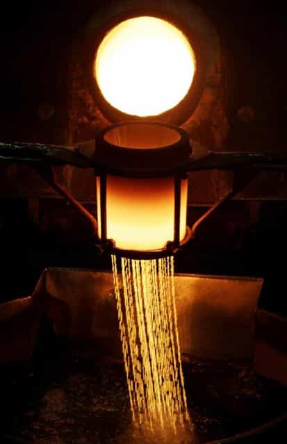 Strings of melted gold are pour into a water bath from a furnace with temperatures exceeding 1000 degrees centigrade at the Emirates Gold company in Dubai, United Arab Emirates. Dubai has set up gold refineries, vaults and jewelry-making facilities giving it a about a 29 percent market share of global gold trade. (Photo by Kamran Jebreili/AP Photo)