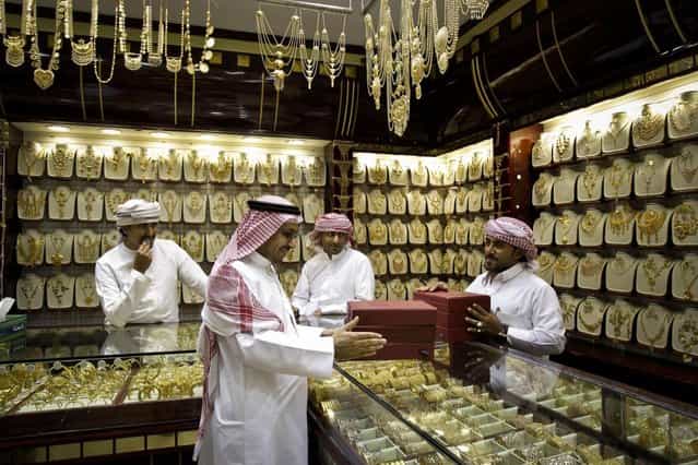 A Saudi customer discusses his purchases at a jewelry shop in the gold suq, or market, in Dubai, United Arab Emirates. The price of gold in Dubai is fixed daily and items are sold by weight. with little or no or little charge for the often exquisite workmanship. (Photo by Kamran Jebreili/AP Photo)
