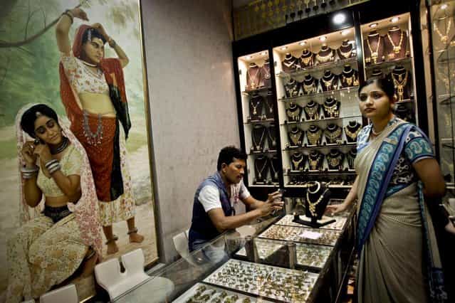 A customer uses his calculator to convert a jewelry price at a jewelry shop in the gold suq in Dubai, United Arab Emirates. (Photo by Kamran Jebreili/AP Photo)