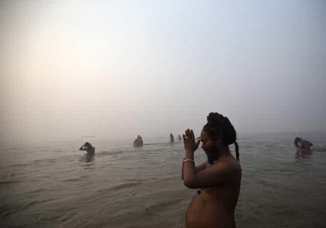 A Sadhu or a Hindu holy man prays as he takes a dip during the first [Shahi Snan] (grand bath) at the ongoing [Kumbh Mela], or Pitcher Festival, in the northern Indian city of Allahabad January 14, 2013. Upwards of a million elated Hindu holy men and pilgrims took a bracing plunge in India's sacred Ganges river to wash away lifetimes of sins on Monday, in a raucous start to an ever-growing religious gathering that is already the world's largest. (Photo by Ahmad Masood/Reuters)