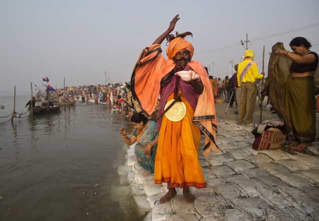 A Sadhu, or a Hindu holy man, performs morning prayers on the banks of the river Ganges ahead of the [Kumbh Mela] (Pitcher Festival) in the northern Indian city of Allahabad January 13, 2013. During the festival, Hindus take part in a religious gathering on the banks of the river Ganges. [Kumbh Mela] will return to Allahabad in 12 years. (Photo by Ahmad Masood/Reuters)