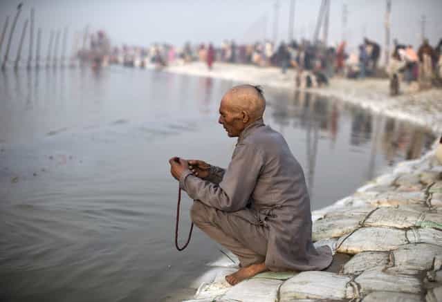 A Hindu devotee holds a prayer bead on the banks of the river Ganges ahead of the [Kumbh Mela] (Pitcher Festival) in the northern Indian city of Allahabad January 13, 2013. During the festival, Hindus take part in a religious gathering on the banks of the river Ganges. The [Kumbh Mela] will return to Allahabad in 12 years. (Photo by Ahmad Masood/Reuters)