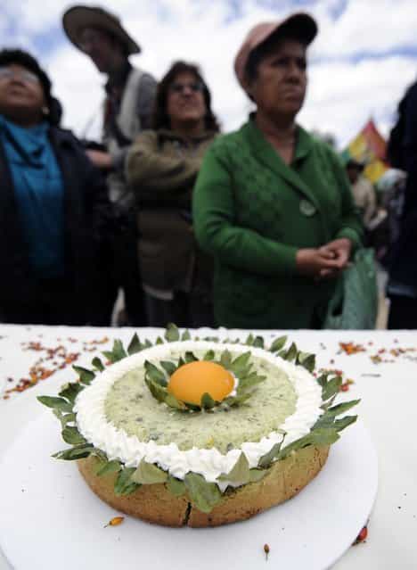 Women stand next to a pie made with coca flour during a celebration for the reincorporation of Bolivia to the UN Convention Against Illicit Traffic in Narcotic Drugs in La Paz on January 14, 2013. "The coca leaf is not any more seen as cocaine (..), it is a victory of our identity" said Bolivian President Evo Morales. AFP PHOTO/Jorge Bernal (Photo credit should read JORGE BERNAL/AFP/Getty Images)