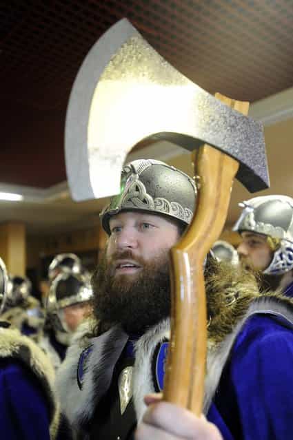 A participant dressed as a Viking holds his axe aloft as he prepares to participate in the annual Up Helly Aa festival in Lerwick, Shetland Islands on January 29, 2013. Up Helly Aa celebrates the influence of the Scandinavian Vikings in the Shetland Islands and culminates with up to 1,000 'guizers' (men in costume) throwing flaming torches into their Viking longboat and setting it alight later in the evening. AFP PHOTO / ANDY BUCHANAN (Photo credit should read Andy Buchanan/AFP/Getty Images)