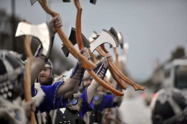 Participants dressed as Vikings march past during the annual Up Helly Aa festival in Lerwick, Shetland Islands on January 29, 2013. Up Helly Aa celebrates the influence of the Scandinavian Vikings in the Shetland Islands and culminates with up to 1,000 'guizers' (men in costume) throwing flaming torches into their Viking longboat and setting it alight later in the evening. AFP PHOTO / ANDY BUCHANAN (Photo credit should read Andy Buchanan/AFP/Getty Images)