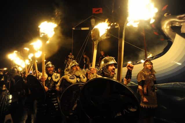 Members of the 2013 'Jarl Squad' take part in the annual Up Helly Aa festival which culminates in the burning of a Viking Galley in Lerwick, Shetland Islands on January 29, 2013. Up Helly Aa celebrates the influence of the Scandinavian Vikings in the Shetland Islands and has employed this theme in the festival since 1870. The event culminates with up to 1,000 'guizers' (men in costume) throwing flaming torches into their Viking longboat. AFP PHOTO / ANDY BUCHANAN (Photo credit should read Andy Buchanan/AFP/Getty Images)