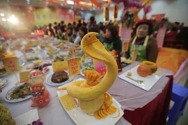 A dish created in the shape of a snake is presented on a table as residents stand around, during an annual local celebration for the upcoming Chinese New Year in Wuhan, Hubei province, February 4, 2013. In a celebration that has been held for some 13 years, community members cooked more than 8000 dishes as new year gifts for their elderly and needy neighbours, The Lunar New Year, also known as the Spring Festival, begins on February 10 and marks the start of the Year of the Snake, according to the Chinese zodiac. Picture taken February 4, 2013. (Photo by Darley Shen/Reuters)
