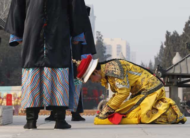 A performer dressed as a Qing dynasty emperor bows while he prays in an ancient Qing Dynasty ceremony, in which emperors prayed for good harvest and fortune, during the temple fair at Ditan Park, also known as the Temple of Earth, in Beijing February 9, 2013. The Lunar New Year, or Spring Festival, begins on February 10 and marks the start of the Year of the Snake, according to the Chinese zodiac. (Photo by Kim Kyung-Hoon/Reuters)