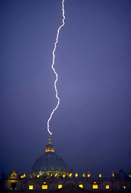 A lightning strikes St Peter's dome at the Vatican on February 11, 2013. Pope Benedict XVI announced today he will resign as leader of the world's 1.1 billion Catholics on February 28 because his age prevented him from carrying out his duties – an unprecedented move in the modern history of the Catholic Church. (Photo by Filippo Monteforte/AFP Photo)