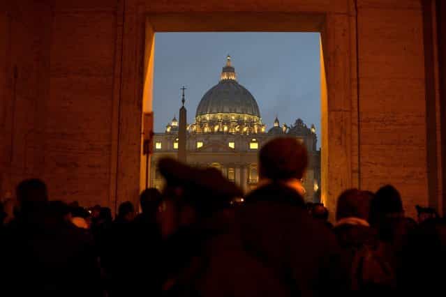 People gather in front of Saint Peter's dome at the Vatican on February 11, 2013 after Pope Benedict XVI announced he will resign as leader of the world's 1.1 billion Catholics on February 28 because his age prevented him from carrying out his duties – an unprecedented move in the modern history of the Catholic Church. (Photo by Filippo Monteforte/AFP Photo)