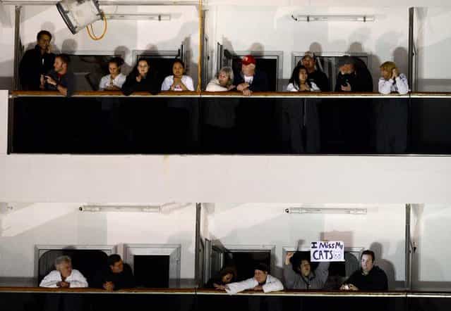 People watch from their balconies aboard the Carnival Triumph after it was towed to the cruise terminal in Mobile, February 14, 2013. (Photo by John David Mercer/Associated Press)