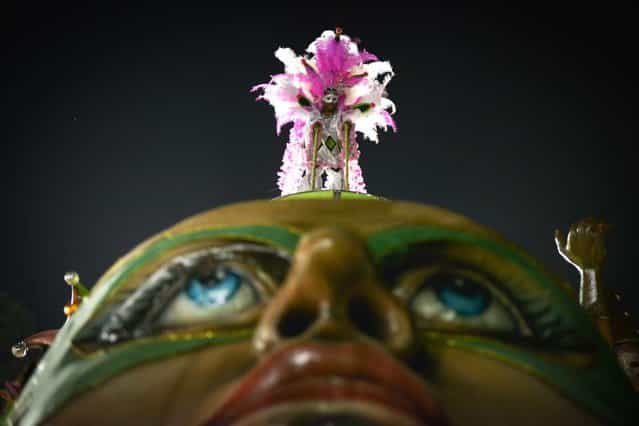A reveller of Barroca Zona Sul samba school stands atop a float during the last day of the carnival parades at the Sambadrome in Sao Paulo, Brazil, on February 12, 2013. Barroca this year is focusing its carnival theme on the history of Jabaquara, an ethnically diverse district that includes Jardim Oriental, a community that is home to many Japanese. (Photo by Yasuyoshi Chiba/AFP Photo)