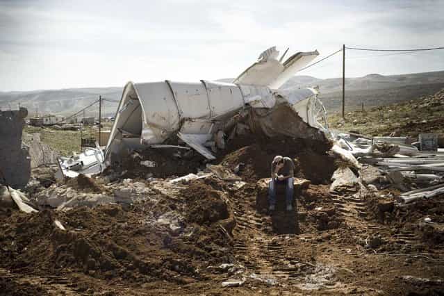 An Israeli settler sits praying among the rubble of his house that was demolished by Israeli police in the outpost of Maale Rehavam, in the Israeli occupied Palestinian West Bank, on February 13, 2013. The house was built without any authorization outside the larger state-sanctioned settlement. The number of Israeli settlers in the occupied West Bank grew by 4.7% in 2012, according to figures obtained by AFP from a settler organisation. (Photo by Janos Chiala/AFP Photo)