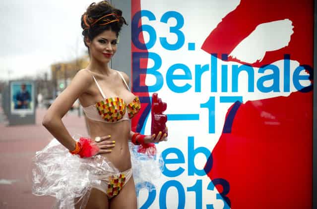 German model Micaela Schaefer wearing a gummy bear bikini poses with a giant gummy bear on the [Boulevard of the Stars] next to a Berlinale poster in Berlin on February 1, 2013. (Photo by Odd Andersen/AFP Photo)