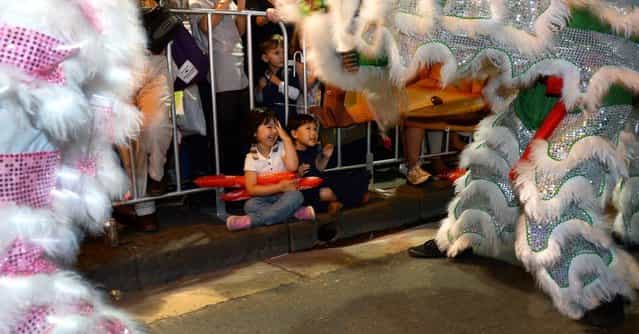Young children watch dragons pass in the Chinese New Year parade in Sydney on February 17, 2013. The parade featured more than 3,500 performers from Australia and China, including 120 performers from Shenzhen, Sydney's offical partner city for this year's festival. (Photo by William West/AFP Photo)