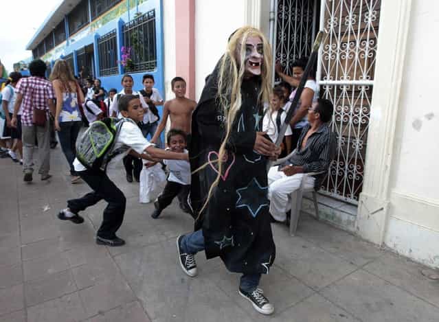 A masked reveller runs through the street during the IX International Festival of Poetry in Granada city, about 45 km (28 miles) south of Managua, February 20, 2013. About 300 poets from around the world along with Nicaraguans participated in the IX international poetry festival dedicated to Nicaraguan poet Ernesto Cardenal who won the Queen Sofia Prize of 2012. (Photo by Oswaldo Rivas/Reuters)