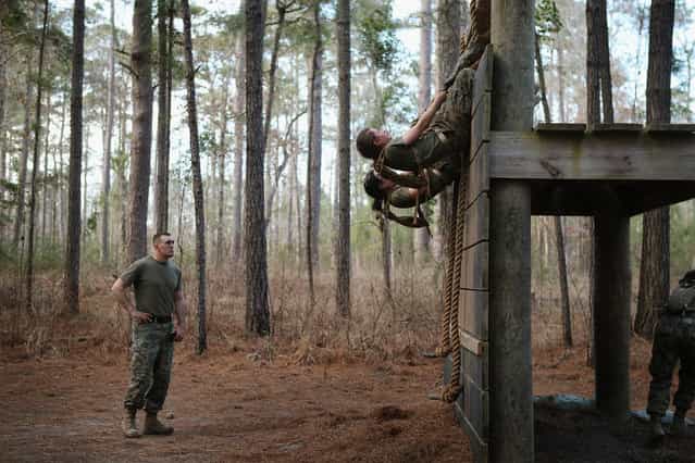 Sgt. Adam Lewis of Council Bluffs, Iowa works with female Marines as they try to climb an obstacle on the Endurance Course during Marine Combat Training (MCT) on February 20, 2013 at Camp Lejeune, North Carolina. Since 1988 all non-infantry enlisted male Marines have been required to complete 29 days of basic combat skills training at MCT after graduating from boot camp. MCT has been required for all enlisted female Marines since 1997. About six percent of enlisted Marines are female. (Photo by Scott Olson)