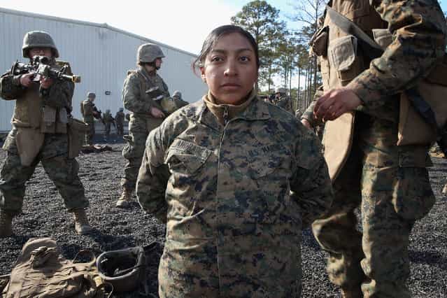 Pvt. Toni Rodriguez (L) of Naugatuc, Connecticut, Roxsana Andrade (C) of Fairfax, Virginia and Pfc. Cristiana Alvarez from Milwaukee, Wisconsin work on search procedures during Marine Combat Training (MCT) on February 20, 2013 at Camp Lejeune, North Carolina. Since 1988 all non-infantry enlisted male Marines have been required to complete 29 days of basic combat skills training at MCT after graduating from boot camp. MCT has been required for all enlisted female Marines since 1997. About six percent of enlisted Marines are female. (Photo by Scott Olson)