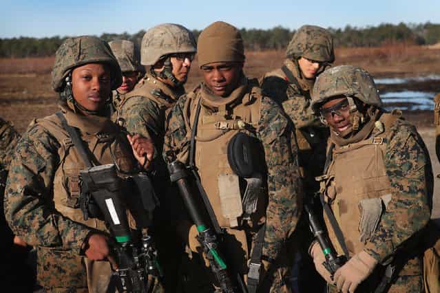 Male and female Marines wait their turn on the range during a combat marksmanship course at Marine Combat Training (MCT) on February 20, 2013 at Camp Lejeune, North Carolina. Since 1988 all non-infantry enlisted male Marines have been required to complete 29 days of basic combat skills training at MCT after graduating boot camp. It has been required for enlisted female Marines since 1997. About six percent of enlisted Marines are female. (Photo by Scott Olson)