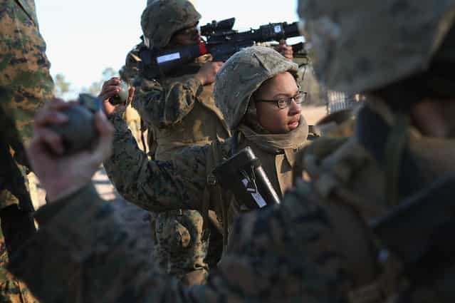 Pvt. Gina Rodriguez prepares to throw a practice grenade during Marine Combat Training (MCT) on February 21, 2013 at Camp Lejeune, North Carolina. Since 1988 all non-infantry enlisted male Marines have been required to complete 29 days of basic combat skills training at MCT after graduating from boot camp. MCT has been required for all enlisted female Marines since 1997. About six percent of enlisted Marines are female. (Photo by Scott Olson)