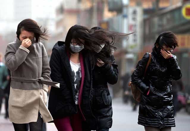 Chinese women, some wearing face masks, brace through strong wind after the capital city is hit by sandstorm in Beijing Thursday, February 28, 2013. (Photo by Andy Wong/AP Photo)