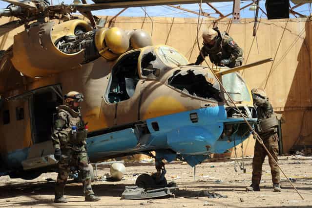 French army deminers secure a helicopter in a hangar at the Gao airport, on February 9, 2013. Two Malian soldiers and four civilians have already been killed by landmines, and French troops are still fighting off what Paris called [residual jihadists] in reclaimed territory. (Photo by Pascal Guyot/AFP Photo/The Atlantic)