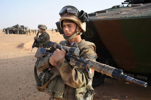 A French army sniper stands next to an armored vehicle outside Bourem, Mali, on February 17, 2013. (Photo by Pascal Guyot/AP Photo/The Atlantic)