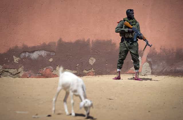 Malian army soldier Sekou Bolly, 30, holds an AK-47 assault rifle as he patrols in Gao, on February 25, 2013. (Photo by Joel Saget/AFP Photo/The Atlantic)