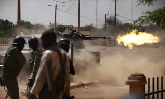 Malian soldiers fire a large weapon in Gao, on February 21, 2013. French and Malian troops fought Islamists on the streets of Gao, as fighting showed little sign of abating weeks before France plans to start withdrawing some forces. (Photo by Joe Penney/Reuters/The Atlantic)