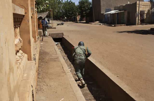 A Malian soldier runs in an empty gutter during fighting with Islamists in Gao, on February 21, 2013. (Photo by Joe Penney/Reuters/The Atlantic)