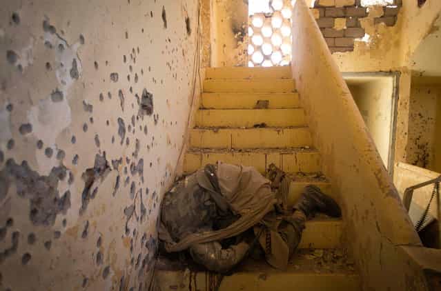 The body of an Islamist fighter, on a staircase in central Gao, following a gun battle on February 22, 2013. (Photo by Joel Saget/AFP Photo/The Atlantic)